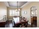 Dining room with a large dark wood table, chandelier lighting, and shuttered windows at 13507 W 87Th Ter, Arvada, CO 80005