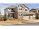 Inviting two-story home boasts a neutral exterior with a manicured front lawn and attached garage at 13507 W 87Th Ter, Arvada, CO 80005