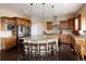 Gourmet kitchen featuring custom wood cabinetry, a central island, and stainless steel appliances at 13507 W 87Th Ter, Arvada, CO 80005