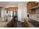 Modern kitchen featuring stainless steel appliances, a gas cooktop, custom cabinets, and granite countertops at 13507 W 87Th Ter, Arvada, CO 80005