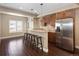 Basement kitchenette with stainless steel refrigerator, wood cabinets, and barstool seating at 13507 W 87Th Ter, Arvada, CO 80005