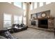 Bright living room with a stone fireplace and large windows providing natural light and a warm atmosphere at 13507 W 87Th Ter, Arvada, CO 80005