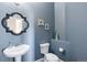 Stylish powder room with a blue color scheme, pedestal sink, and decorative mirror at 13507 W 87Th Ter, Arvada, CO 80005
