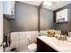 Cozy bathroom featuring a wood vanity with white countertop, neutral gray walls and a modern toilet at 19709 Rosewood Ct, Parker, CO 80138