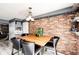 Dining room features a wooden table, stylish chairs, brick accent wall, and decorative shelves at 19709 Rosewood Ct, Parker, CO 80138