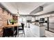 Eat-in kitchen features stainless steel appliances, granite countertops, a center island, and brick wall at 19709 Rosewood Ct, Parker, CO 80138