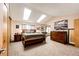 Bright primary bedroom with vaulted ceiling, skylights and wood furnishings at 19709 Rosewood Ct, Parker, CO 80138