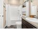 A full bathroom with a shower-tub combo, white tile surround, and modern vanity at 91 S Quantock St, Aurora, CO 80018
