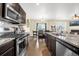 Open kitchen with stainless steel appliances, granite countertops, and a view of the dining and living areas at 91 S Quantock St, Aurora, CO 80018