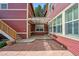 Back patio featuring red siding, stone floors and stairs to a balcony at 2502 Alton St, Denver, CO 80238