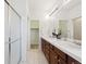 Ensuite bathroom with dual vanity, dark wood cabinetry, bright lighting, and walk-in shower at 2502 Alton St, Denver, CO 80238
