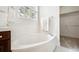 Bright bathroom featuring tiled bathtub and shower, storage closet and natural light at 2502 Alton St, Denver, CO 80238