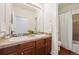 Bathroom with double vanity, framed mirror, accent tile and private access to the shower and toilet at 2502 Alton St, Denver, CO 80238