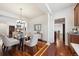 Bright dining room with hardwood flooring, a glass table, and convenient access to other rooms at 2502 Alton St, Denver, CO 80238