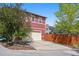 Two-story home featuring a driveway, attached garage, and wood fence at 2502 Alton St, Denver, CO 80238