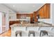 Spacious kitchen featuring a breakfast bar, stainless steel appliances, and warm wood cabinetry at 2502 Alton St, Denver, CO 80238