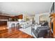 Open-concept living space with seamless kitchen access, a fireplace, and hardwood floors at 2502 Alton St, Denver, CO 80238