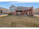 Home's backyard with a deck and stairs; grass is dormant, showing brick and blue siding at 22725 E Long Dr, Aurora, CO 80016