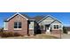 Charming home with a brick and gray facade, complemented by a well-maintained yard and an American flag at 22725 E Long Dr, Aurora, CO 80016