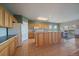 Bright kitchen featuring wood cabinets, an island, and access to a dining area with outdoor views at 22725 E Long Dr, Aurora, CO 80016