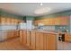 Well-lit kitchen featuring wood cabinets, a spacious countertop, and functional layout at 22725 E Long Dr, Aurora, CO 80016