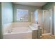 Relaxing main bathroom with a soaking tub, separate glass shower, and a large window at 22725 E Long Dr, Aurora, CO 80016