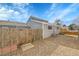 Fenced backyard area featuring gravel groundcover and a wooden gate at 16403 E Radcliff Pl # A, Aurora, CO 80015