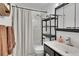 Bright bathroom featuring a shower over tub, sleek vanity, and decorative storage at 16403 E Radcliff Pl # A, Aurora, CO 80015