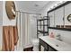 Bright bathroom featuring a shower over tub, sleek vanity, and decorative storage at 16403 E Radcliff Pl # A, Aurora, CO 80015