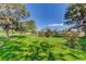 Expansive backyard featuring a well-manicured lawn, mature trees, and a charming pergola with blooming roses, creating a serene outdoor space at 3561 Kalispell St, Aurora, CO 80011