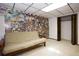 Finished basement with futon, drop ceiling, unique wall decorations, and closet at 3561 Kalispell St, Aurora, CO 80011