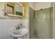 Charming bathroom featuring an ornate mirror, pedestal sink, and tiled stand-up shower at 3561 Kalispell St, Aurora, CO 80011
