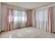 Well-lit bedroom with plush carpeting and large windows dressed with pastel curtains at 3561 Kalispell St, Aurora, CO 80011