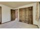 Bedroom featuring carpet flooring, closet with wood panel doors and two entryways at 3561 Kalispell St, Aurora, CO 80011