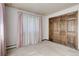 Carpeted bedroom featuring a wooden closet and natural light from window at 3561 Kalispell St, Aurora, CO 80011