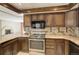 Modern kitchen featuring stainless steel oven, granite countertops, and abundant cabinetry at 3561 Kalispell St, Aurora, CO 80011