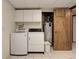 Laundry room featuring tile floors, white appliances, and a utility sink at 3561 Kalispell St, Aurora, CO 80011