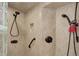 Shower featuring dual shower heads, neutral tile surround, and grab bar at 3561 Kalispell St, Aurora, CO 80011