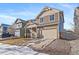 Two-story house with beige and brown siding, attached garage, and landscaping at 5385 Walden Ct, Denver, CO 80249