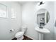 Small powder room with pedestal sink and toilet at 5385 Walden Ct, Denver, CO 80249