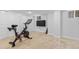 Basement workout area with exercise bike, neutral carpet, white walls, and wall mounted television at 3334 W 37Th Ave, Denver, CO 80211