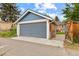 View of detached one car garage with blue siding and brick accents plus concrete driveway at 3334 W 37Th Ave, Denver, CO 80211