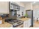 Modern kitchen with granite countertops, black backsplash, gas range, and stainless steel appliances at 3334 W 37Th Ave, Denver, CO 80211