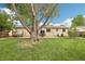 Expansive backyard showcases lush greenery, mature trees, patio seating, and a relaxing hot tub, creating an inviting outdoor space at 7075 Welch Ct, Arvada, CO 80004
