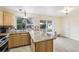 Bright kitchen featuring stainless steel appliances, granite countertops, light wood cabinetry and a view to the gazebo at 7075 Welch Ct, Arvada, CO 80004