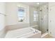 Bright bathroom featuring a soaking tub, walk-in shower and tiled accents at 5682 N Galena St, Denver, CO 80238