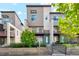 Modern townhome with a neutral exterior, colorful accents, and landscaping at 5682 N Galena St, Denver, CO 80238