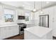 Modern kitchen with stainless steel appliances, white cabinetry, and stone countertops at 5682 N Galena St, Denver, CO 80238