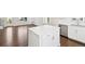 Kitchen island with white cabinets and hardwood flooring at 5682 N Galena St, Denver, CO 80238