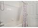 Clean white bathroom with a shower featuring a floral shower curtain and white tile at 11083 Quail Ct, Parker, CO 80134